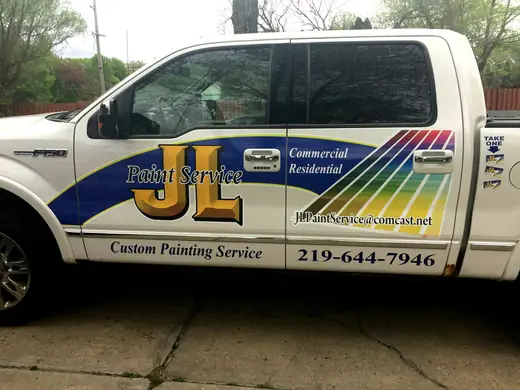 White pickup with colorful striped business lettering