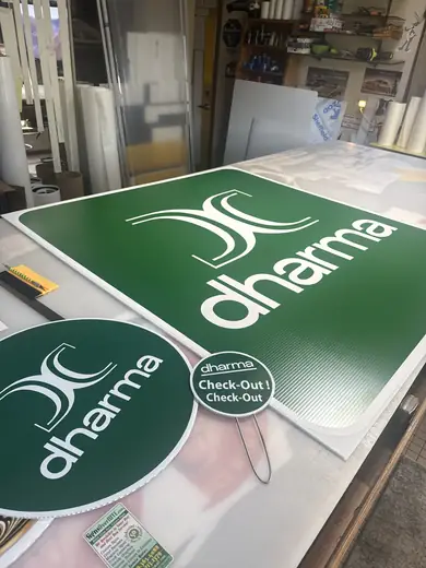 Green and white cut-vinyl logo lettering on a work table